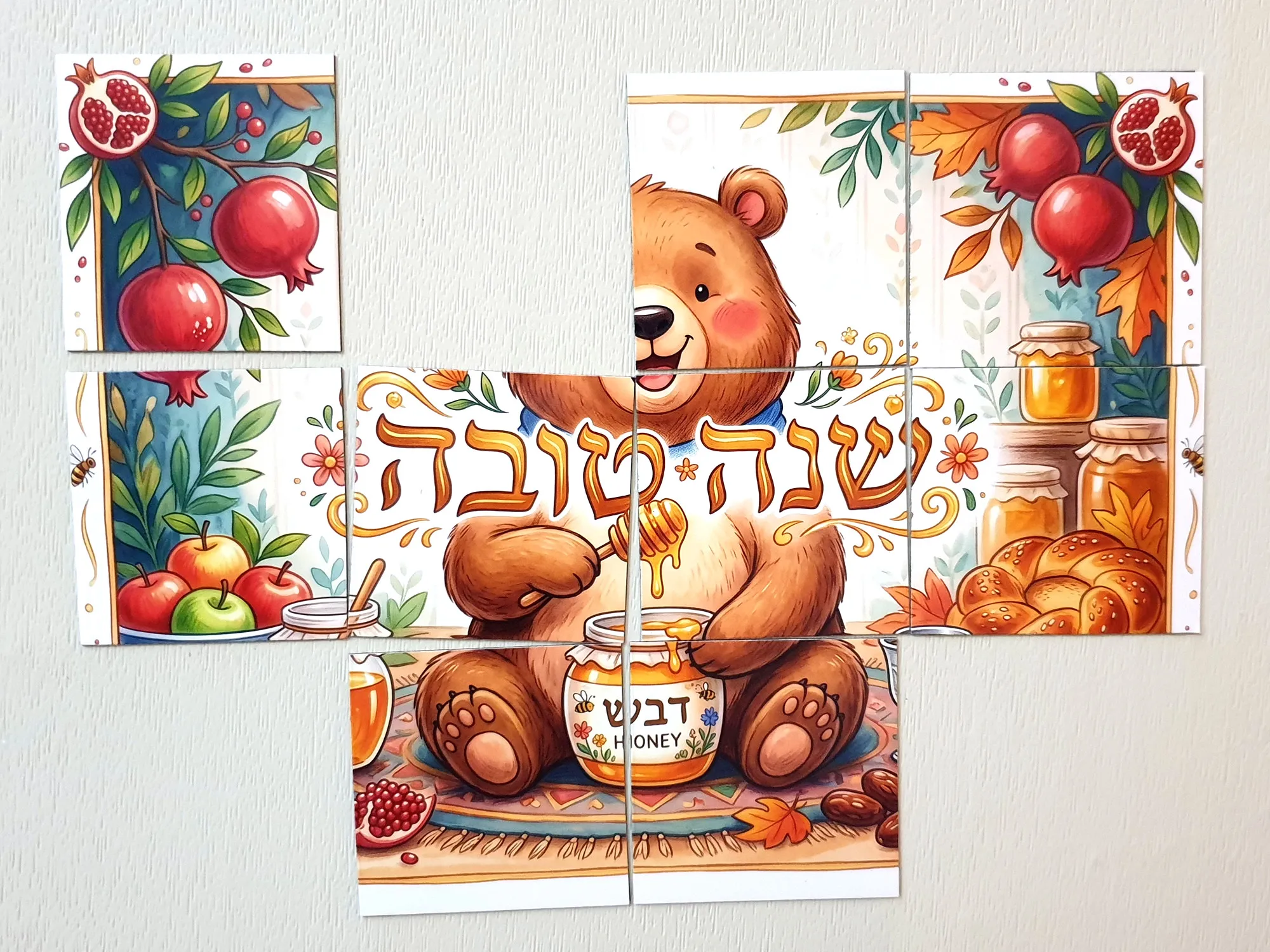 איור של דוב חמוד יושב מול צנצנת דבש עם כף דבש, מוקף ברימונים, תפוחים וחלה, ומעליו הכיתוב שנה טובה - זווית נוספת